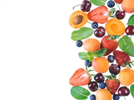 Apricot, strawberries, cherry, blueberries and mint leaves isolated on white background with copy space. Food background, mix of berries, healthy food, superfood, diet, detox concept. Top view