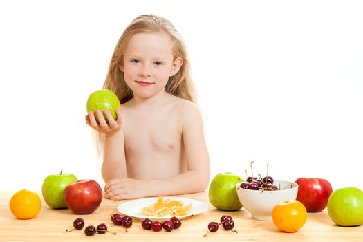 the little girl is fruit at a table on the isolated background