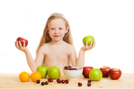 the little girl is fruit at a table on the isolated background