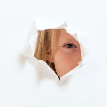 the little girl looks out through a hole in paper