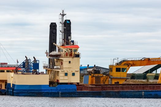 Blue cargo ship loading in the port of Riga, Europe