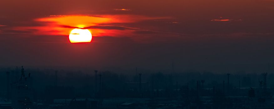 Hot orange sunset over the river. Urban landscape
