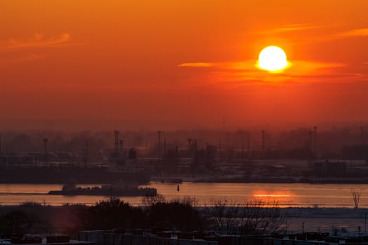 Hot orange sunset over the river. Urban landscape
