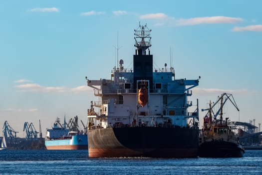 Black cargo ship entering the port of Riga, Europe
