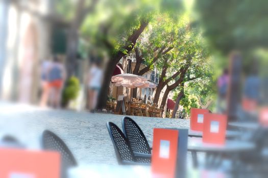 Artistic work of my own. Intentional blur at this design
Narrow historic street with restaurant and cafes in the village of Valldemossa on Mallorca, Spain