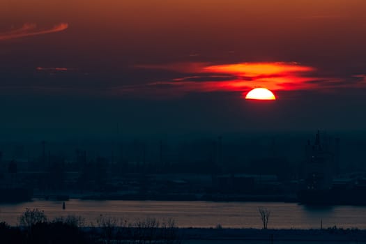 Hot orange sunset over the river. Urban landscape