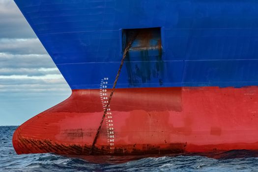 Blue cargo ship moored in still Baltic sea water