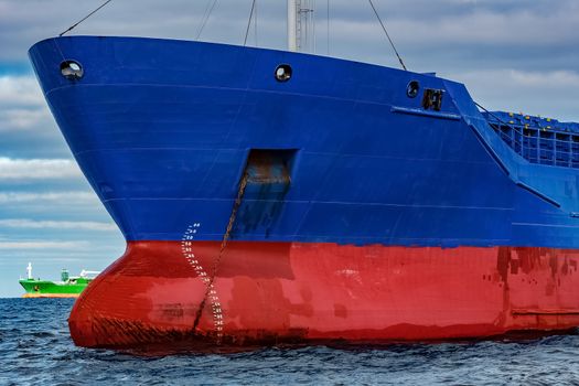 Blue cargo ship moored in still Baltic sea water