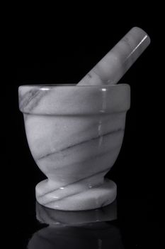 White marble mortar with a pestle on a black background