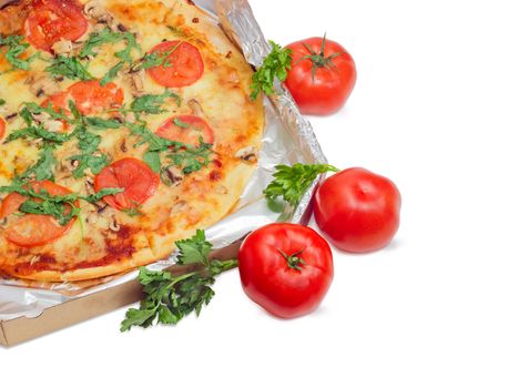 Fragment of the cooked round pizza with tomatoes, mushrooms and arugula wrapped in aluminum foil in the open cardboard box and three fresh tomatoes beside on a light background
