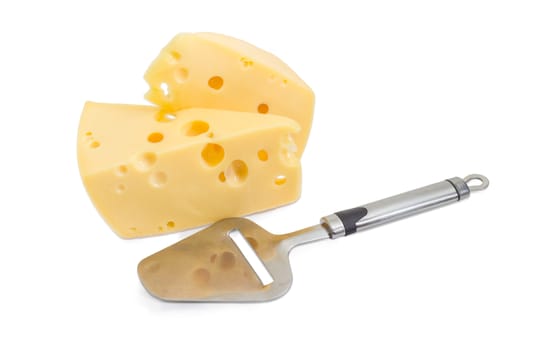 Cheese slicer against the background of the two pieces of the semi-hard Swiss-type cheese on a light background
