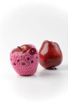 two red apples, one in crochet apple cozy
