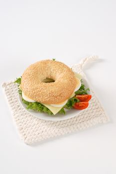 bagel sandwich with eggs and cheese on white plate