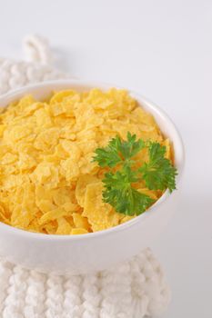 bowl of corn flakes on white table mat