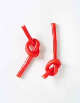 knotted soft strawberry candy sticks on white background