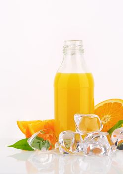 bottle of orange juice and ice cubes on white background
