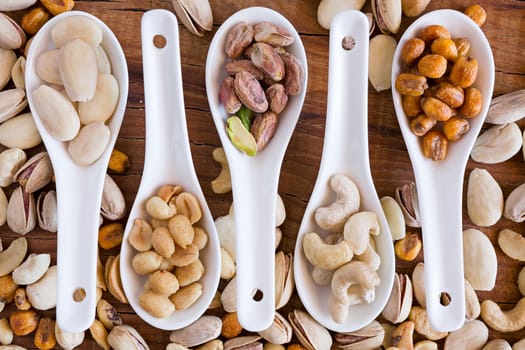 Closeup of mix of nuts over a rustic table seen from above