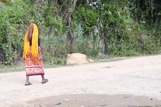 African woman looking back on a path in the bush