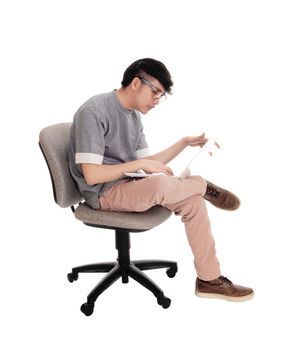 A young Asian man sitting and working hart on his laptop to solve the
problem, with glasses isolated for white background.
