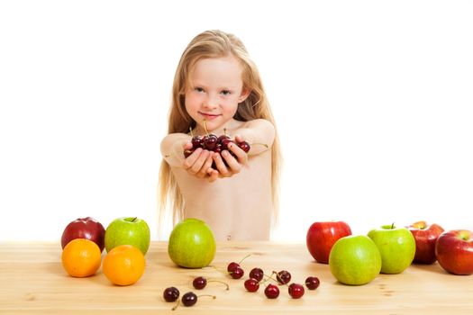 the little girl is fruit at a table on the isolated background