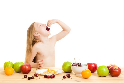 the little girl is fruit at a table on the isolated background