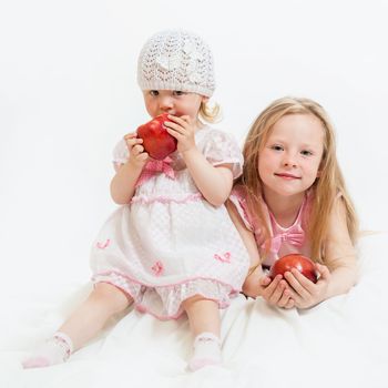 two little girls sit on the isolated background