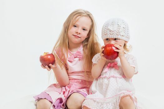 two little girls sit on the isolated background