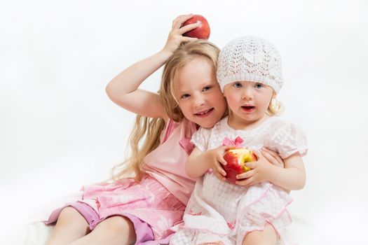 two little girls sit on the isolated background