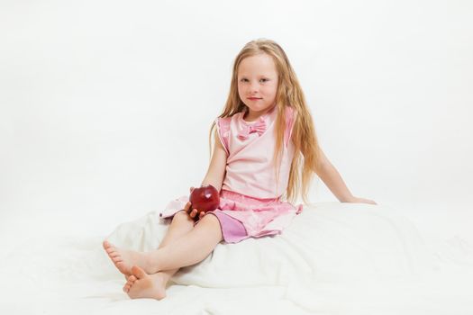 the beautiful little girl with apple on the isolated background