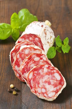 Sliced French Saucisson Sec on wooden background