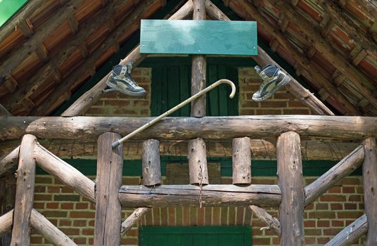 A wooden cabin with walking boots and walking stick in a forest