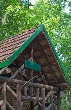 A wooden cabin with walking boots and walking stick in a forest