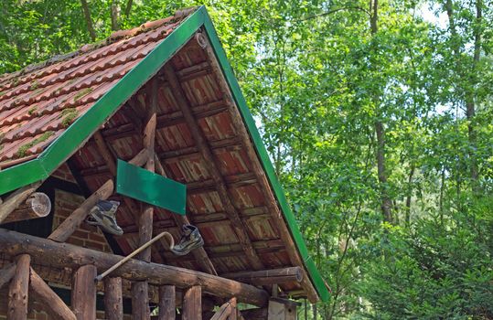 A wooden cabin with walking boots and walking stick in a forest