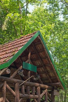 A wooden cabin with walking boots and walking stick in a forest