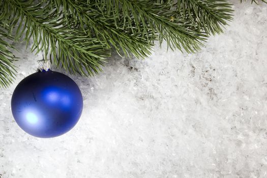 Christmas ball and spruce branch in the snow