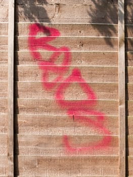 a red spray paint stain outside on a wooden garden fence