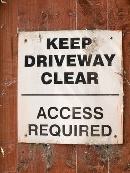 keep driveway clear access required parking sign on wooden shed garden wall