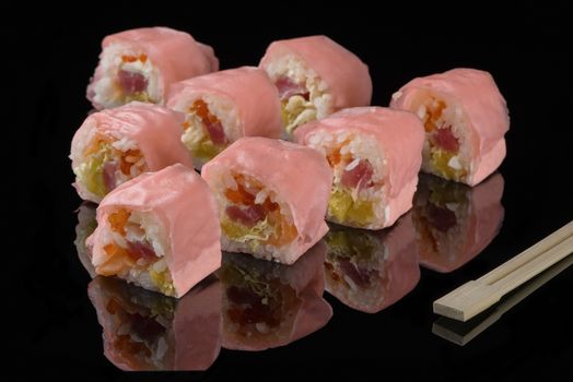 Pink beaters and wooden sticks for sushi on black acryle with reflection