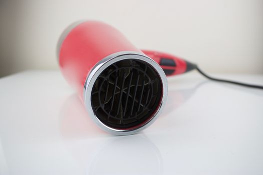 Pink hair dryer on the white table. Hair salon concept.