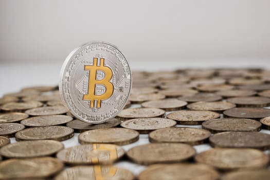 Cryptocurrency physical silver bitcoin coin with yellow currency sign.