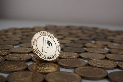 Digital currency physical gold peercoin coin with green leaf on the money.