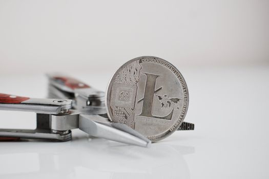 Digital currency physical silver Litecoin coin and silver pocket knife.