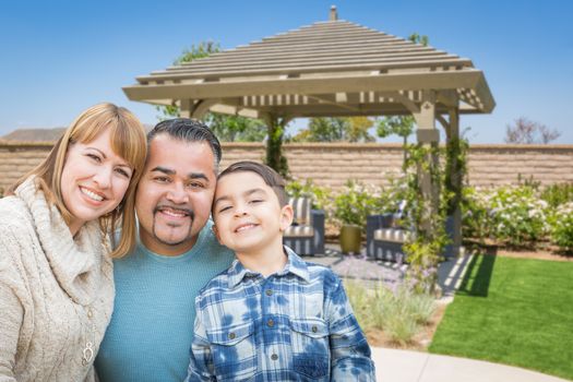Mixed Race Family In Back Yard Near Patio Cover.