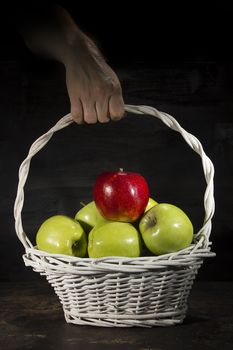 Ripe apples in a wicker basket on a black background