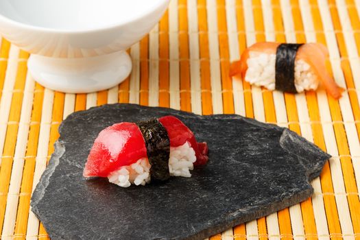 Red tuna Nigiri with Nori seaweed on slate stone.  Raw fish in traditional Japanese sushi style. Horizontal image.