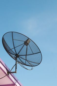 Black satellite dish antennas on blue sky.
