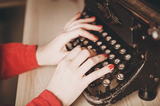 Secretary at old typewriter with telephone. Young woman using typewriter. Business concepts. Retro picture style.