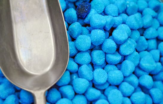 aerial view of blue sugar candies with a metallic shovel