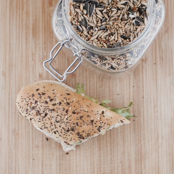 Tasty sandwich in white bread on the wooden board in the kitchen.