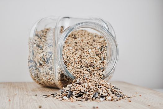 Small seeds in glass jar on the wooden board in the kitchen.